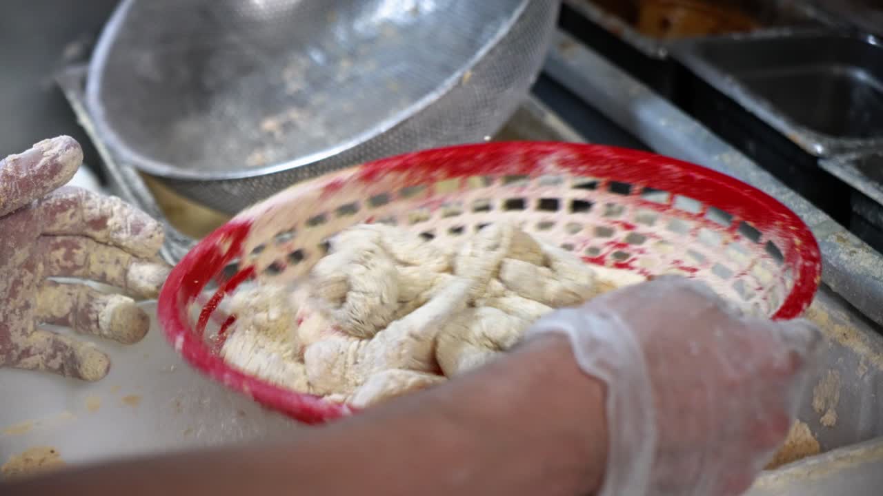 프라이 쿡은 빨간색 바구니를 여과기로 사용하여 생 새우, 슬로우 모션 4k를 빵으로 만듭니다.