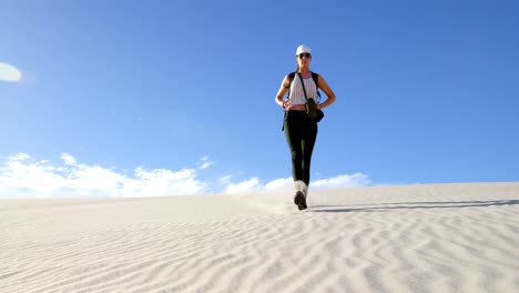 Woman-walking-down-the-sand-dune-in-desert-4k