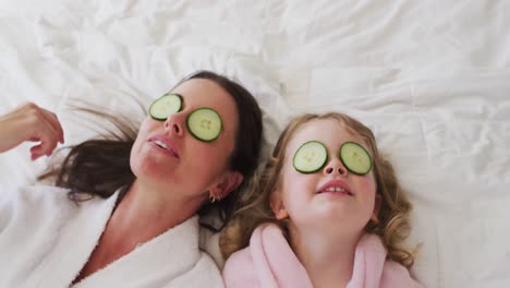 caucasian mother and daughter having fun in bedroom