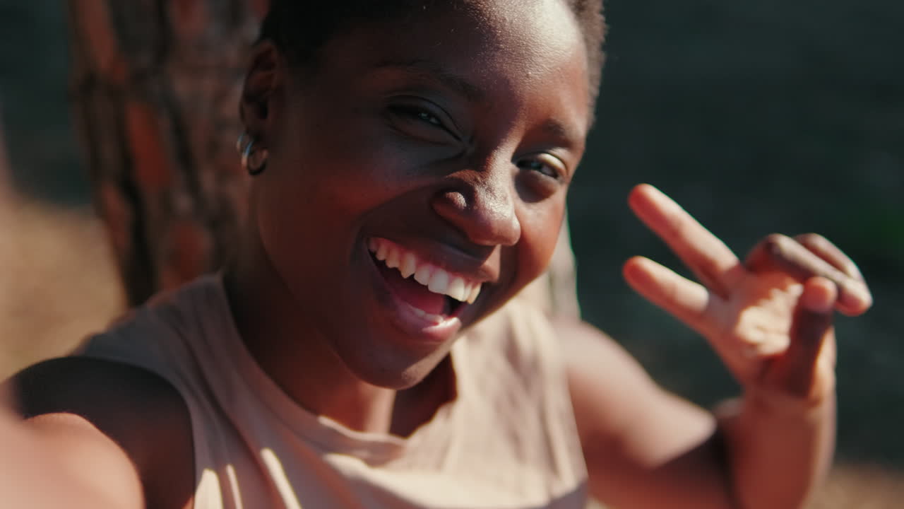 Happy African American Woman Smiling and Waving in Outdoor Selfie Video