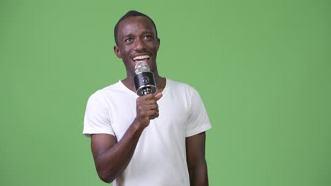 joven africano feliz sonriendo mientras habla en el micrófono