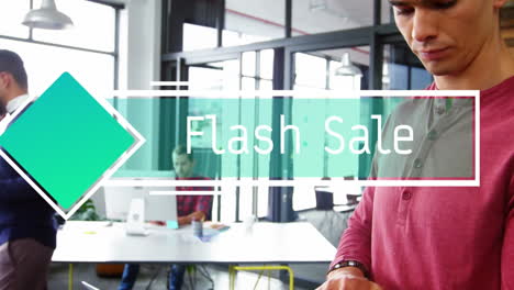 animación de texto de venta flash y hombre de negocios caucásico trabajando en una computadora portátil mientras está de pie en la oficina