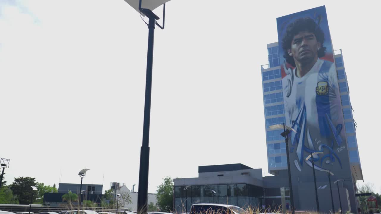 웅장한 건물의 전면을 장식하는 장엄한 마라도나 벽화와 함께 움직이는 만남