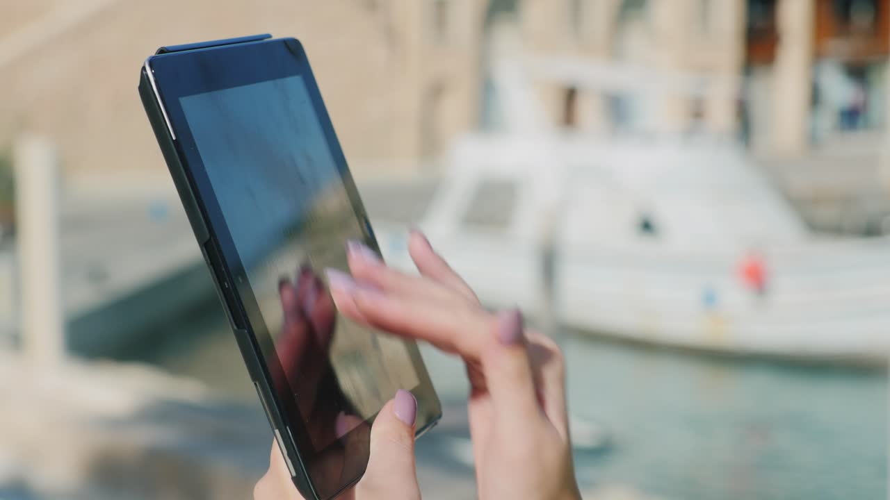 manos con la tableta en el fondo de los yates