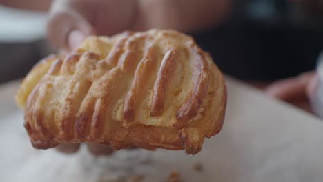 close-up of a golden flaky pastry being held