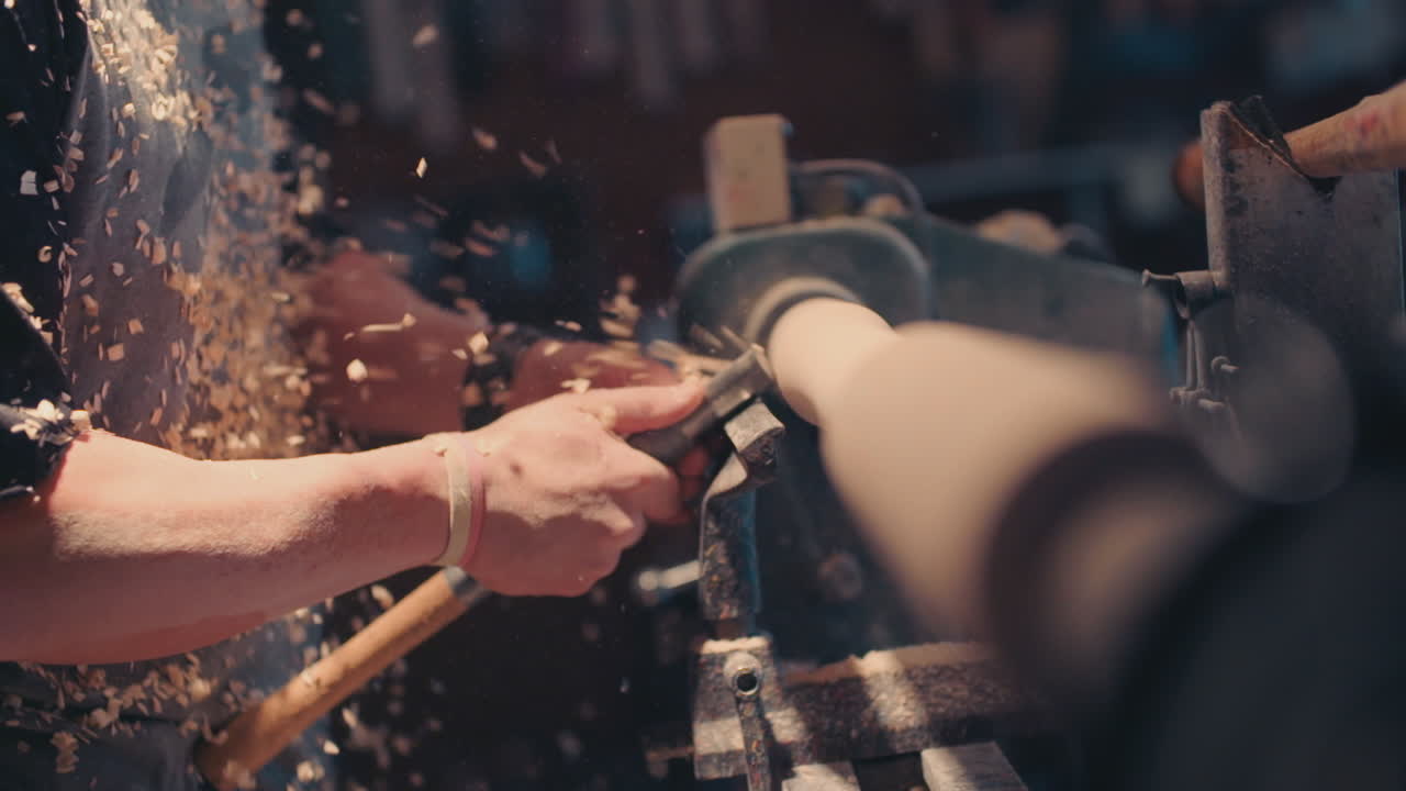 남자가 기계에서 나무를 깎고 있다