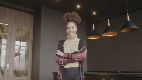 Mujer-Negra,-Con-Los-Brazos-Cruzados-Y-El-Pelo-Recogido,-Sonrisas