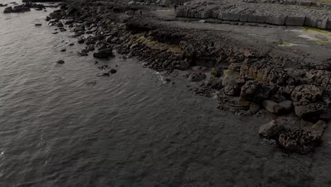 drone pan showing rocks on the beach near the atlantic ocean above the port of doolin by the wild atlantic way in doolin, co