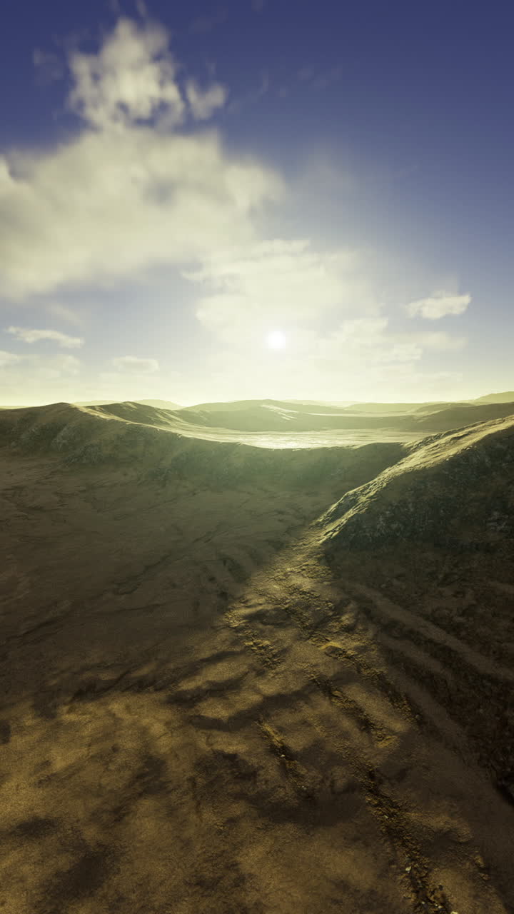 Vast desert landscape with rolling hills and a bright sun at dawn
