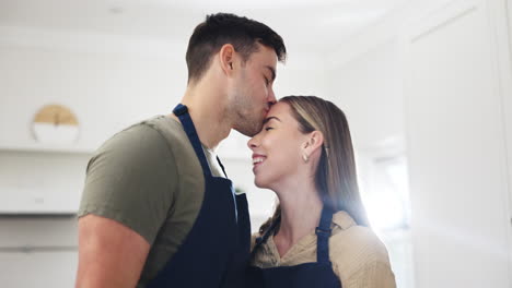pareja, besarse y alimentar comida en la cocina
