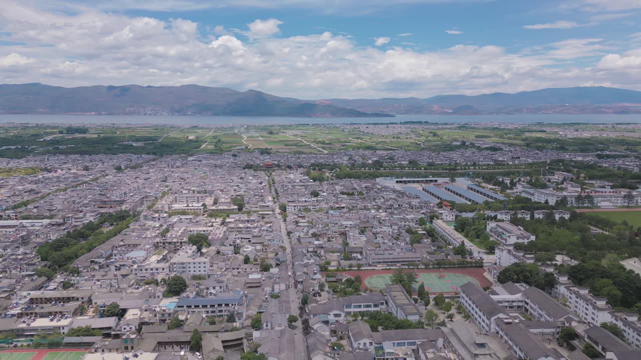 imágenes de drones de panorámica horizontal de la principal calle peatonal de la antigua ciudad de dali, con el magnífico er hai y las montañas en el fondo