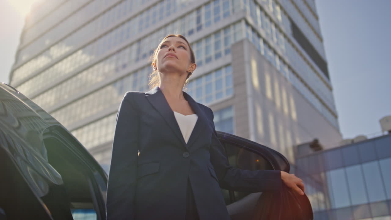 mujer de negocios dejando un automóvil de lujo caminando a la oficina de cerca. mujer abierta