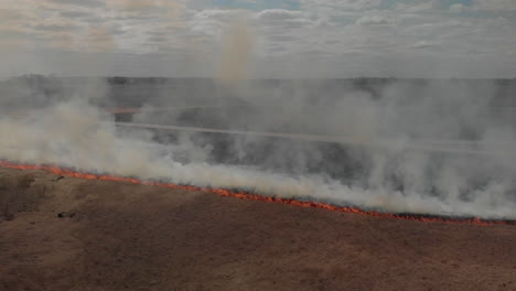 campo de pastizales en llamas con humo