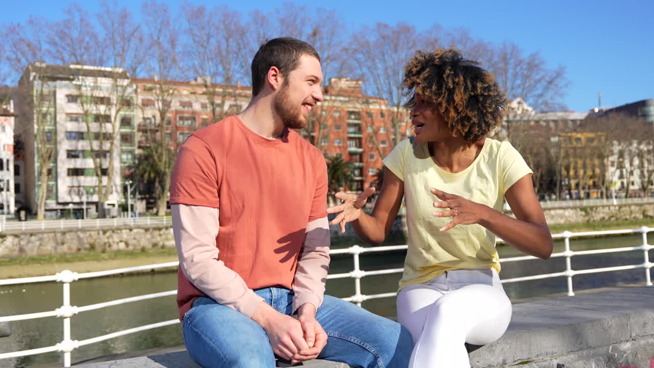 Two people having a conversation on a bridge