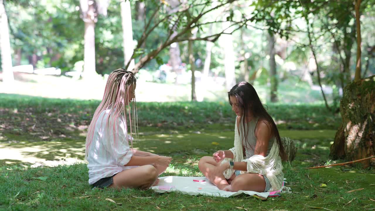 두 여인이 공원에서 피크닉을 즐기고 있다