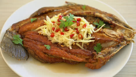 Fried-Sea-Bass-Fish-with-Fish-Sauce-and-Spicy-Salad-on-plate