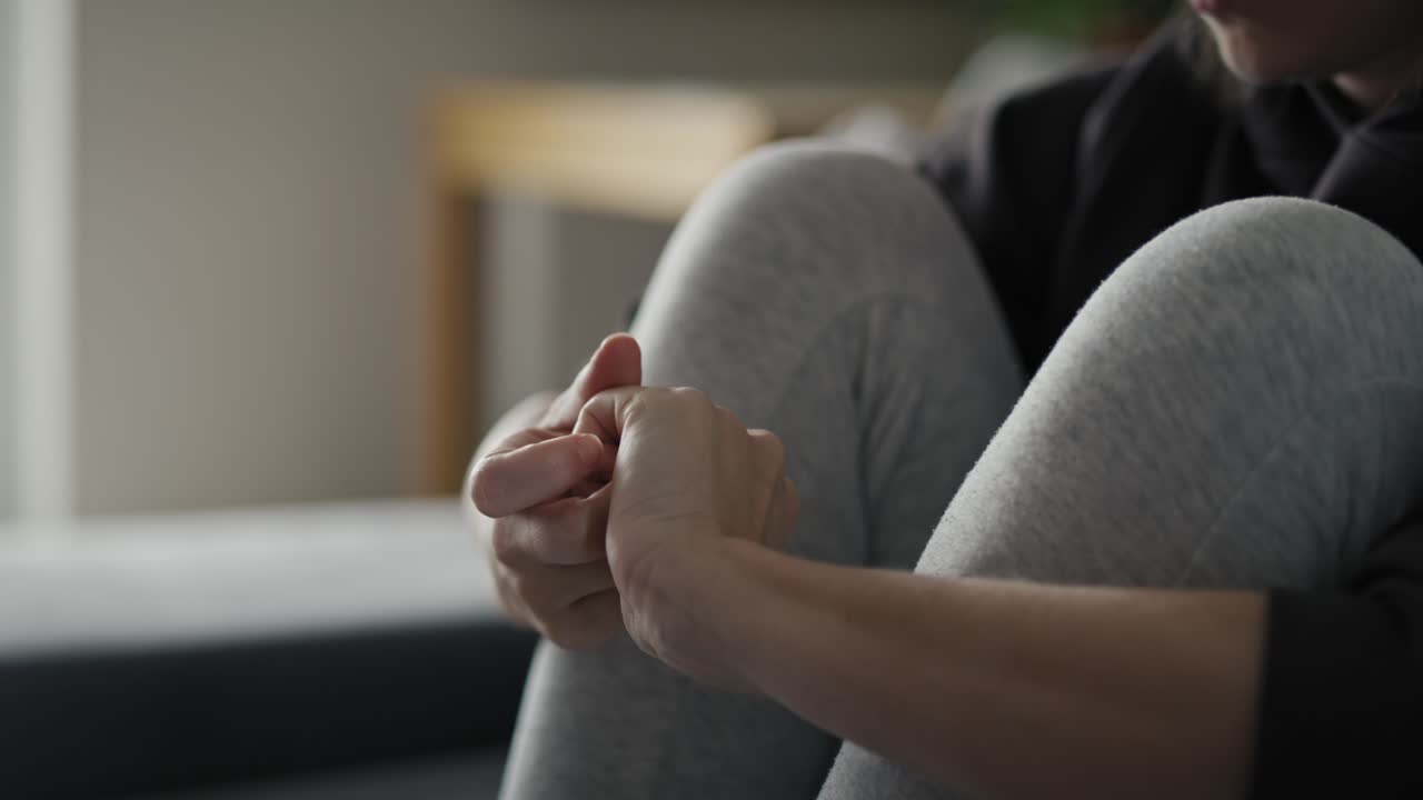 Donna nervosa seduta a casa e concentrata sullo stress.