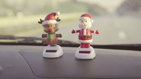 Santa-And-Reindeer-Bobblehead-Dolls-On-The-Dashboard-Say-Merry-Christmas