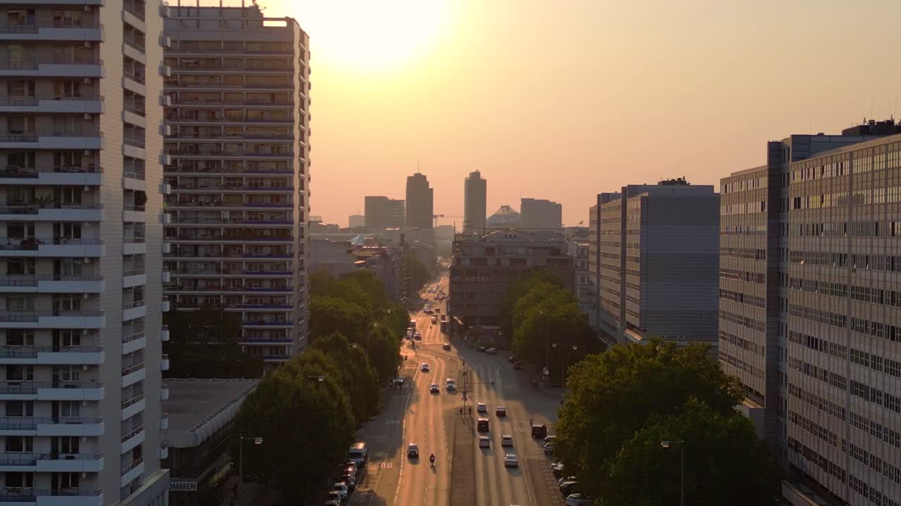 Sunset over a city street with highrise buildings