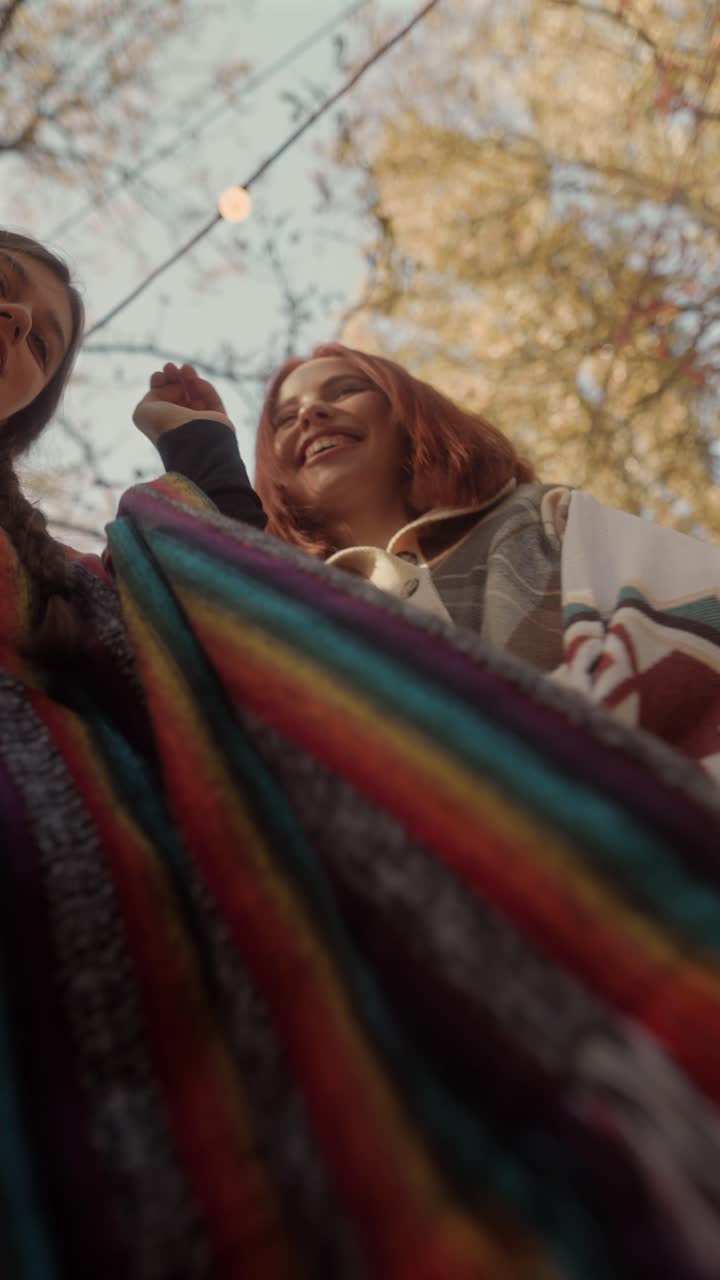 두 명의 행복한 여성들이 가을에 야외에서 웃고 있습니다.