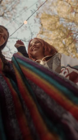 two happy women laughing outdoors in autumn