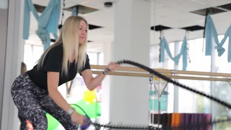 woman exercising with resistance rope in a gym