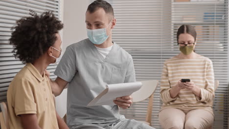 doctor reading patient record to boy