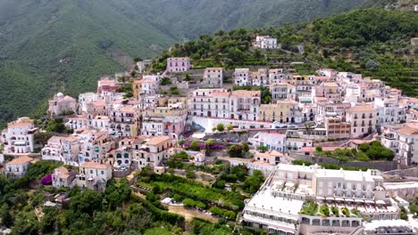 Dolly-Aéreo-Hacia-Arriba-De-Un-Pueblo-Italiano-En-La-Costa-De-Amalfi,-Revelando-Las-Montañas.