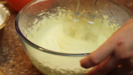 combining sugar egg yolk with hand mixer for cake