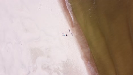 aerial two people running into the baltic sea