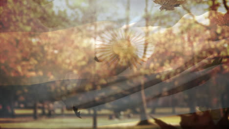 digital composition of argentina waving flag over multiple autumn leaves falling against park