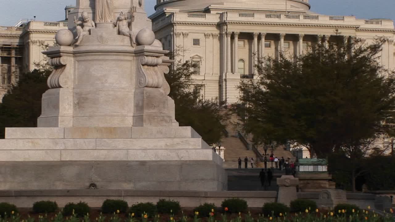 el monumento a la paz de cuarenta y cinco pies de altura que domina el primer plano con el edificio del capitolio de los estados unidos al fondo