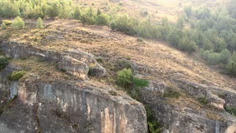 Aerial-flying-down-view-of-a-mountain-with-pine-trees-and-limestone-in-Cuenca