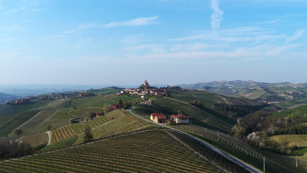 Serralunga d'Alba village and its medieval castle, surrounded by rolling Langhe vineyards, Piedmont, wine, travel, Italy. Aerial drone panoramic view, sky for copy space