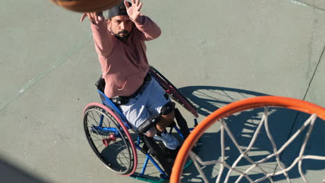 athletic middle-aged man in wheechair playing streetball