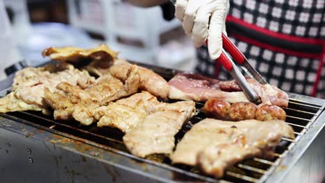 grilling sausages and pork at a street food stall