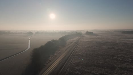 winter sunrise over a foggy country road