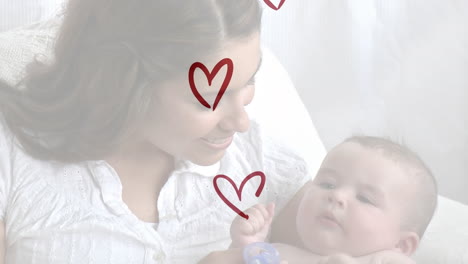 animation of red hearts over smiling caucasian woman with her baby