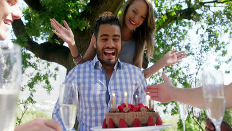 Friends-celebrating-mans-birthday-at-outdoor-restaurant