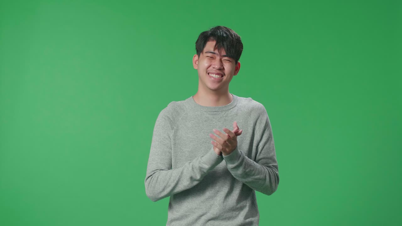 An Asian Man Clapping Her Hands In The Green Screen Studio