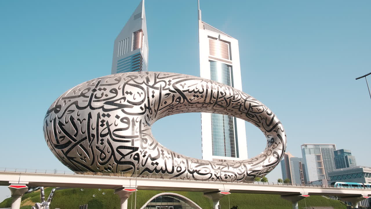 Metro train passing in front of Dubai, Museum of the Future and Emirates Towers