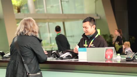 salesman assists customer at museum ticket counter