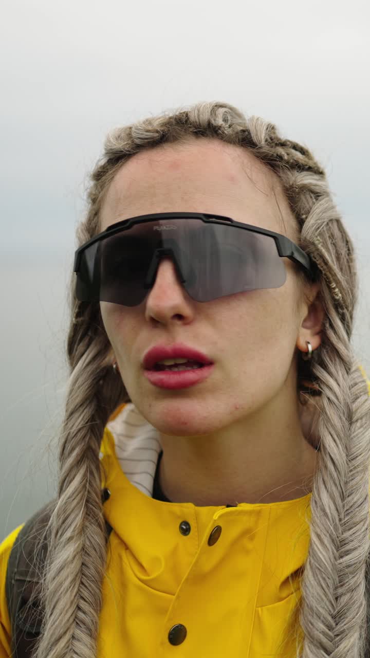 Young Woman in Yellow Raincoat Looking at Lake View