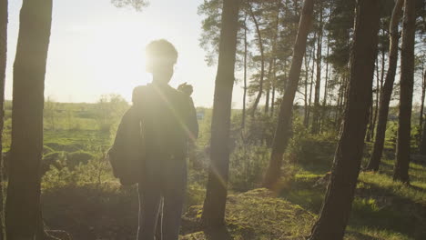 Ein-Hübsches-Mädchen-Fotografiert-Mit-Ihrem-Handy-Den-Wald-Bei-Sonnenuntergang