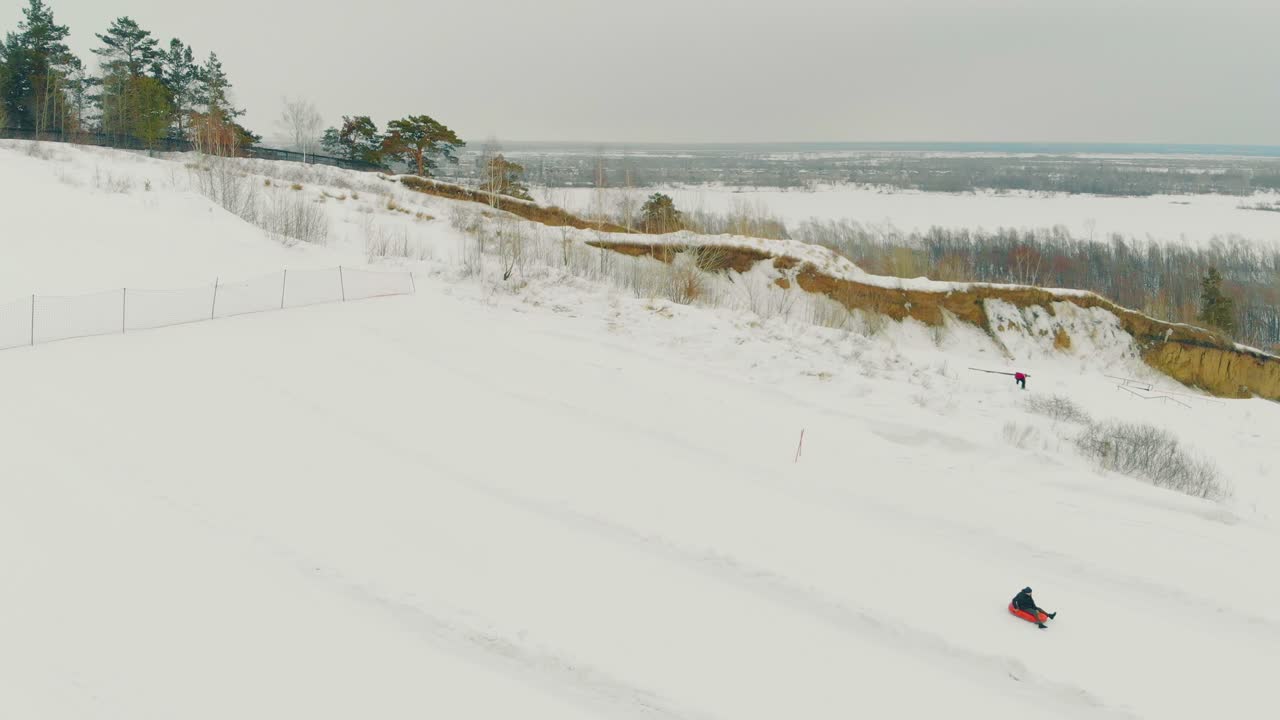 descensos familiares en trineo rojo por una pendiente blanca como la nieve