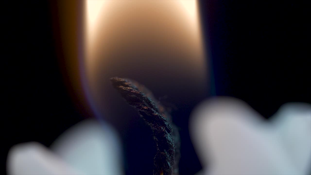 primer plano de una llama de vela y una mecha