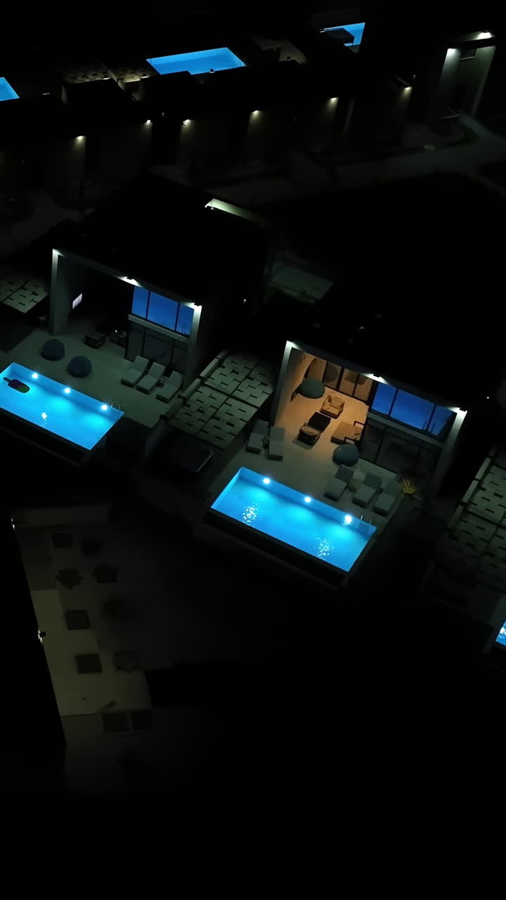 Vertical drone shot around luxurious holiiday villas, summer night in Greece