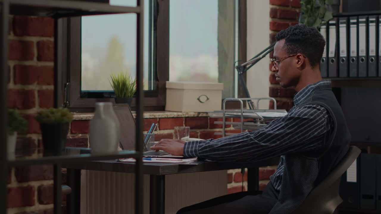 African american person analyzing financial statistics on laptop