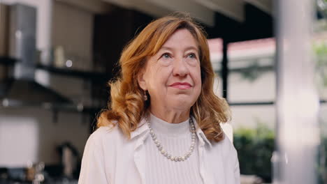 thoughtful senior woman in kitchen