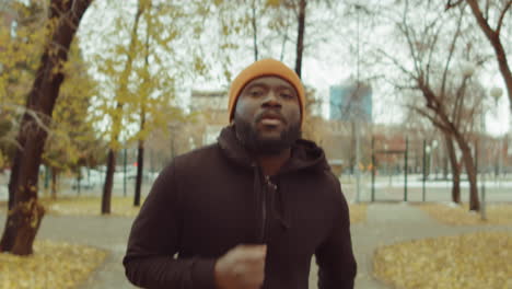 black man running in park on autumn day